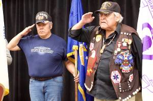 John Phillips (left) and Roger Sheakley salute the colors during the opening of the Southeast Alaska Native Veterans observance of Veterans Day on Saturday at Elizabeth Peratrovich Hall. (Mark Sabbatini / Juneau Empire)