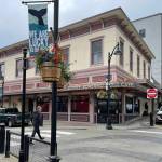 The 125-year-old building at the corner of Front and Seward as seen in summer of 2023. Juneau moved utilities underground and upgraded street lights in the mid-1980s and again recently. Each summer different sayings are displayed on colorful banners (We are lucky to live here on this banner) and flower baskets, bringing lively attention to downtown. (Photo by Laurie Craig)