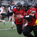 Lance Fenumiai (2), a former Juneau-Douglas High School: Yadaa.at Kalé football player and graduate of the class of 2018, rushes down the field while teammate Tristan Thomas (50), class of 2015, looks to throw a block during the 2023 Juneau Alumni Game played May 26 at Adair-Kennedy Field. (Ben Hohenstatt / Juneau Empire File)