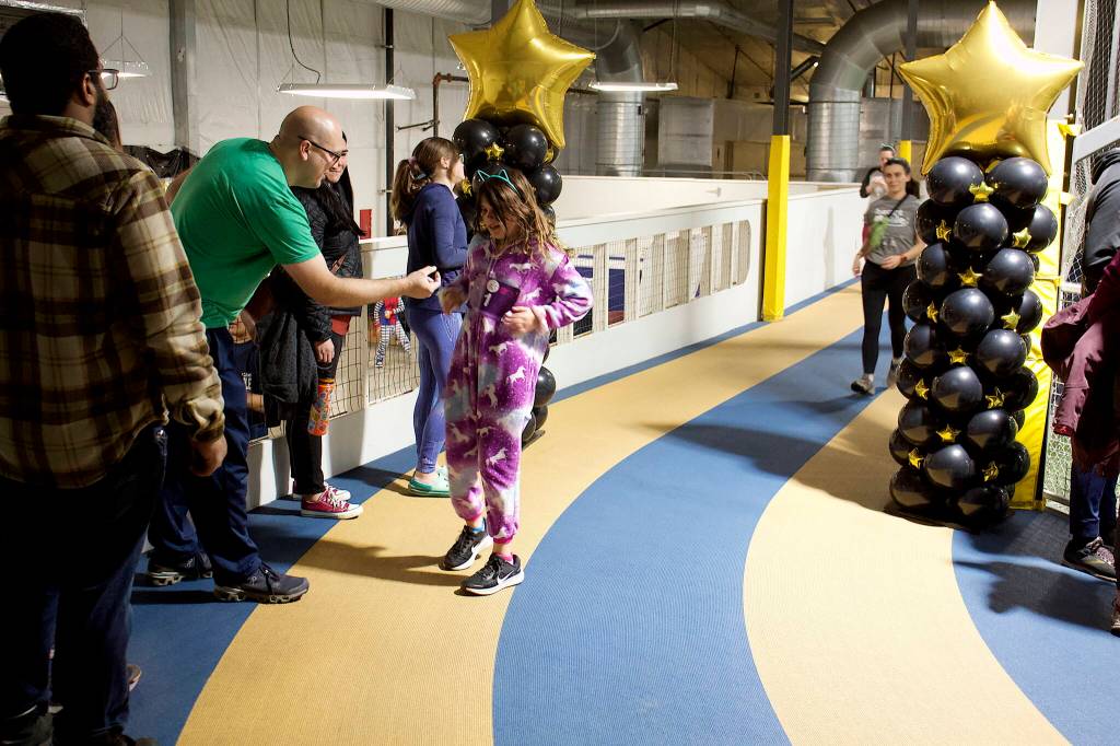 Mark Sabbatini / Juneau Empire
Nora Fortier, 10, gets one of her 27 stars on her race bib from her father, Luke, marking a lap completed during the 5K Pajama Jog at Dimond Park Field House on Sunday afternoon.