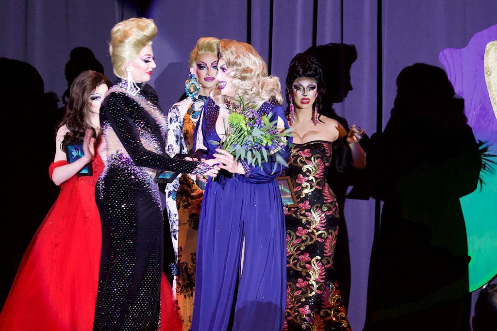 Miss Guise (given name Richard Jay Carter), in blue, is awarded First Runner-Up in the Miss Gay Alaska America Pageant on Saturday night at the Juneau Arts and Culture Center. (Mark Sabbatini / Juneau Empire)