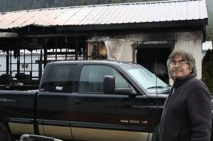 Jerome Dennis stands about five feet from his house in Thunder Mountain Mobile Park, which suffered heat damage, including broken windows, when the house next door caught fire. (Meredith Jordan/ Juneau Empire)