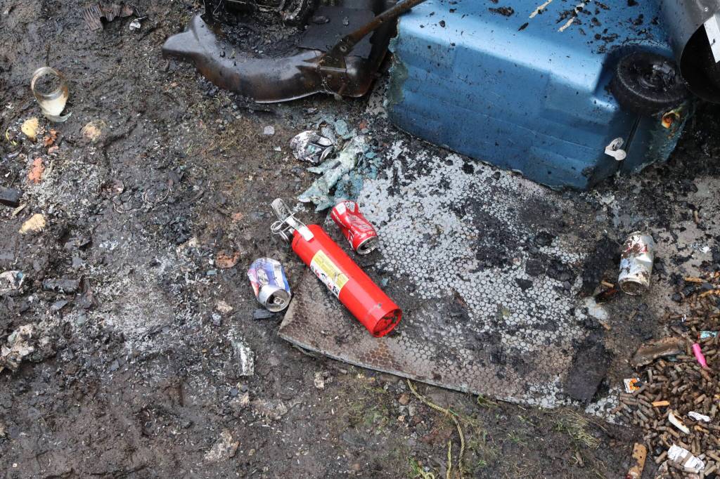 A fire extinguisher stands out in the debris of a fire that gutted a home in Thunder Mountain Mobile Park late Tuesday night. No people or pets were injured. (Meredith Jordan/ Juneau Empire)