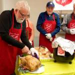 Jerry Harmon performs the ceremonial first carving of a turkey at The Salvation Army Juneau Corps annual communal Thanksgiving meal on Thursday at the Juneau Yacht Club. (Mark Sabbatini / Juneau Empire)