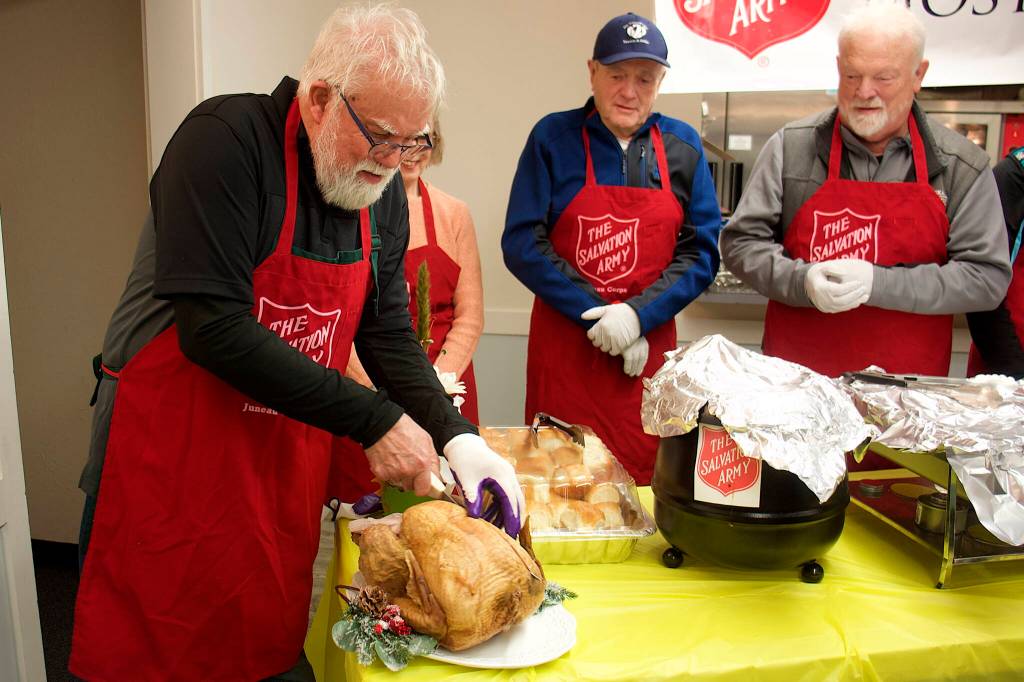 Jerry Harmon performs the ceremonial first carving of a turkey at The Salvation Army Juneau Corps annual communal Thanksgiving meal on Thursday at the Juneau Yacht Club. (Mark Sabbatini / Juneau Empire)
