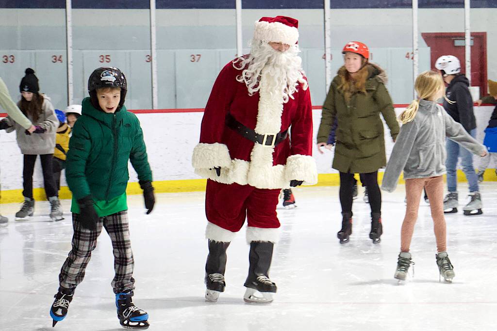 Santa mingles among the crowd on the rink at Treadwell Arena on Friday night. (Mark Sabbatini / Juneau Empire)