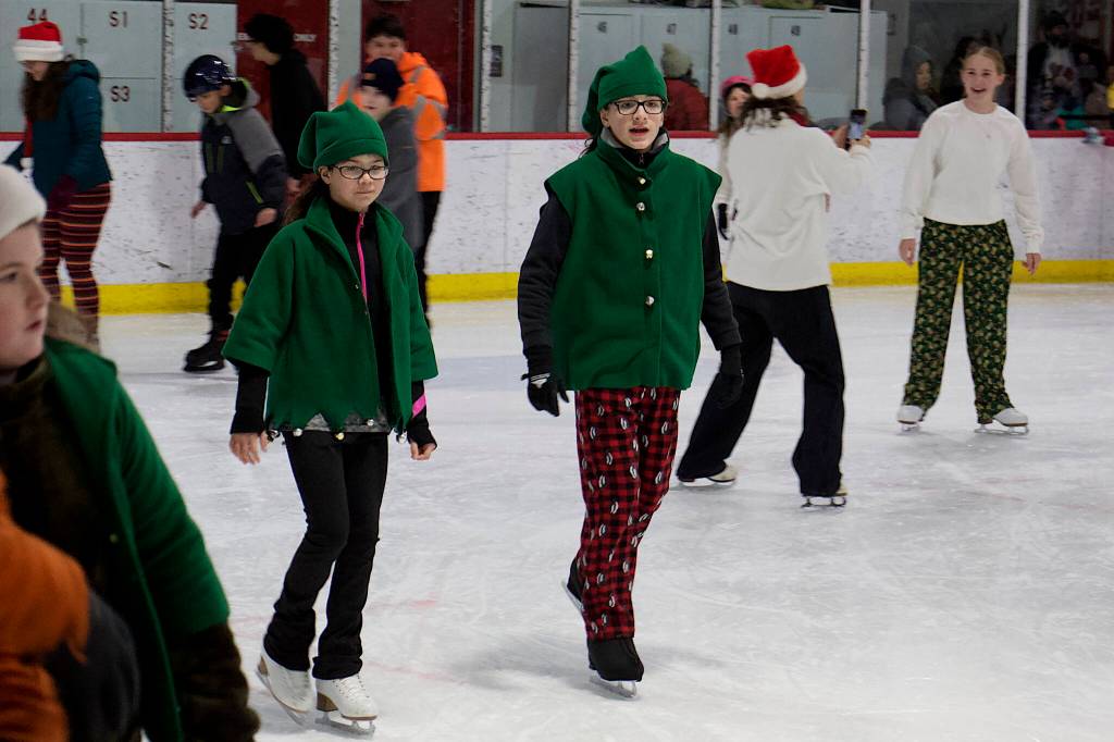 A pair of Santas elves get into the spirit of the season during the annual Santa Skate at Treadwell Arena on Friday night. (Mark Sabbatini / Juneau Empire)