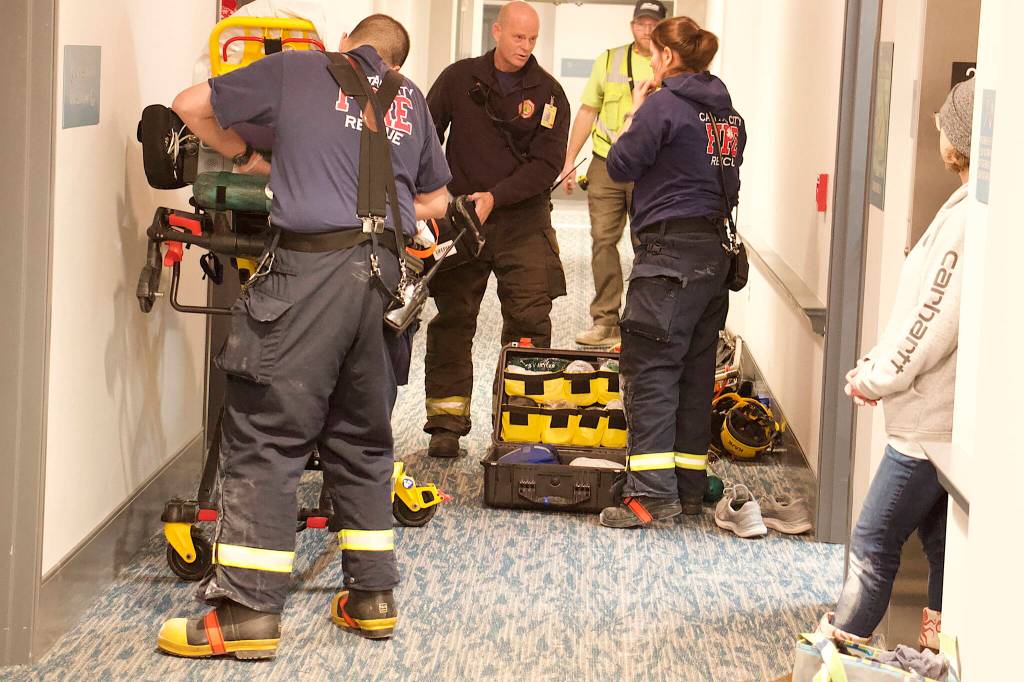 Capital City Fire/Rescue and other workers prepare a stretcher in a hallway of the Riverview Senior Living Center for Nathan Bishop, 58, after he was found late Monday morning in the attic about 40 hours after he was reported missing. (Mark Sabbatini / Juneau Empire)
