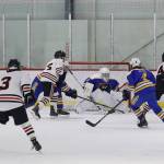 Luke Bovitz (#4 in white jersey) looks to take a shot for Juneau-Douglas High School: Yadaa.at Kalé against Kodiak High School on Saturday night at Treadwell Arena. (Mark Sabbatini / Juneau Empire)