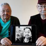 Pauline Golodoff, left, and George Kudrin hold an iPad featuring images of their deceased spouses, Gregory Golodoff and Elizabeth Golodoff Kurdrin, Friday, Dec. 1, 2023, in Anchorage, Alaska. Gregory and Elizabeth were the last two living residents of Attu, Alaska, whose entire population was captured by the Japanese during World War II and sent to Japan until being liberated after the war. The community of Attu was not rebuilt, and residents were resettled elsewhere, mostly in Atka, Alaska. (AP Photo/Mark Thiessen)