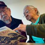 George Kudrin, left, and Pauline Golodoff look at a copy of the book Attu Boy, Friday, Dec. 1, 2023, in Anchorage, Alaska. Gregory Golodoff, Paulines late husband, and Elizabeth Golodoff Kudrin, Georges late wife, were the last two living residents of Attu, Alaska, whose entire population was captured by the Japanese during World War II and sent to Japan until being liberated after the war. Attu Boy was written by Nick Golodoff, who was Gregory and Elizabeths older brother. (AP Photo/Mark Thiessen)