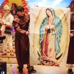 Adriel Cervantes and Emiliano Acevedo, appearing as friars, carry an image of the Virgin Mary at the conclusion of an Our Lady of Guadalupe play at St. Pauls Catholic Church on Sunday. (Mark Sabbatini / Juneau Empire)
