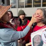 Candace Frank gets a red handprint pressed onto her face at the Missing and Murdered Indigenous People Rally in Juneau on May 5, 2022. (Lisa Phu / Alaska Beacon)