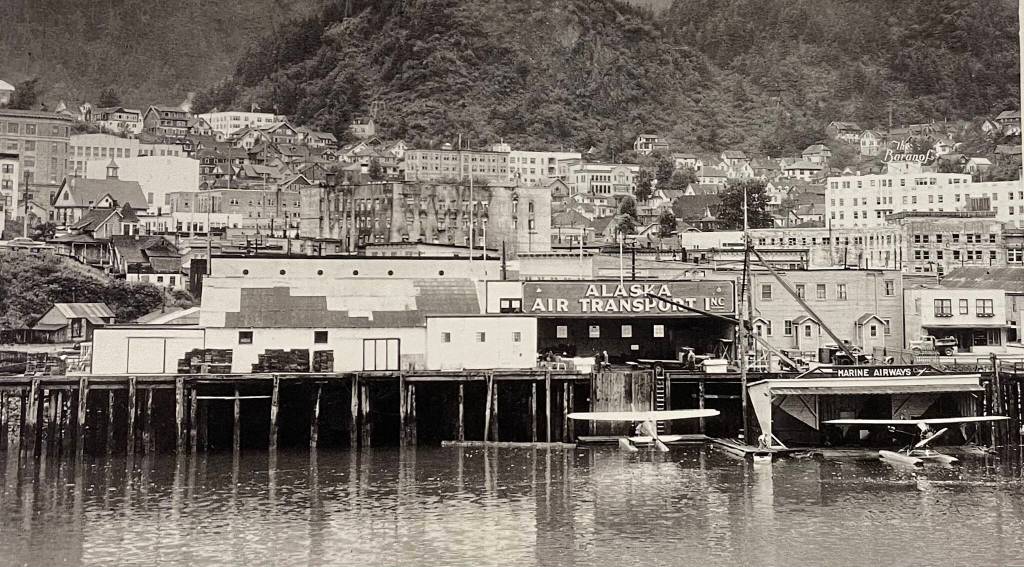 Alaska Air Transport hangar on the pilings dock and Marine Airways on the floating dock kept Juneaus waterfront busy with planes in this undated photo. It is likely taken after 1939 due to the black burn scars on the five-story concrete Goldstein Building exterior in the background. (Photo by Johnston, #1276, Jarman Collection P337)