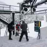 Eaglecrest Ski Area employees clear snow from a lift chair on Sunday, when conditions for opening by this weekend seemed promising. But warmer and wet weather this week means the bottom of the mountain is still not ready for operation, although Eaglecrest Grill will be open this weekend for people wanting to access snow on the upper part of the mountain on their own. (Photo courtesy of Eaglecrest Ski Area.)