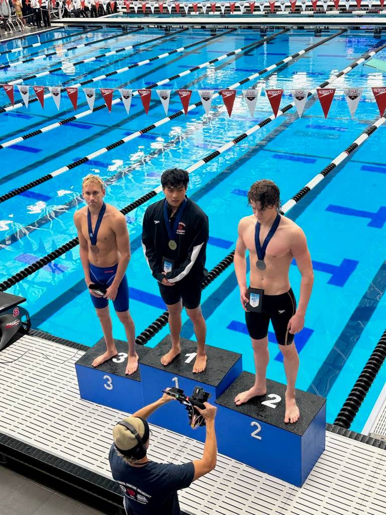 PJ Foy (right) stands on the podium after winning second place in the 100-yard fly during the Speedo Winter Junior Championships in Westmont, Illinois. (Kevin Tuning / Forever Still Photography)