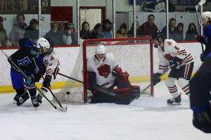 Juneau and Palmer players fight for the puck near the Crimson Bears goal during Saturday nights game between Juneau-Douglas High School: Yadaa.at Kalé and Palmer High School at Treadwell Arena. (Mark Sabbatini / Juneau Empire)