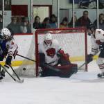 Juneau and Palmer players fight for the puck near the Crimson Bears goal during Saturday nights game between Juneau-Douglas High School: Yadaa.at Kalé and Palmer High School at Treadwell Arena. (Mark Sabbatini / Juneau Empire)