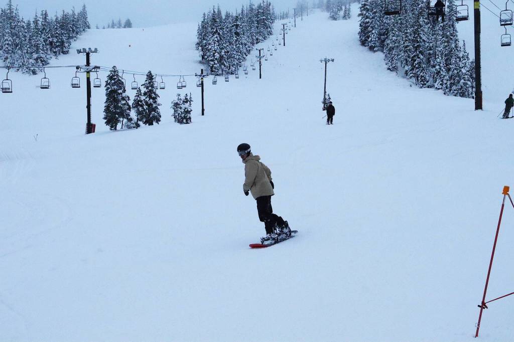 Some of the first snowboarders and skiers at Eaglecrest Ski Area complete their first run on opening day Wednesday morning. (Mark Sabbatini / Juneau Empire)