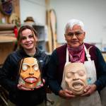 Master Lingít Carver Wayne Price and former University of Alaska student Andrea Cook hold masks done in Prices university class. Price works to protect the standtalls, the massive red cedar trees that are needed to carve totem poles, canoes and other cultural art pieces he sees as integral to a strong future in the arts. (Photo by Bethany Goodrich)