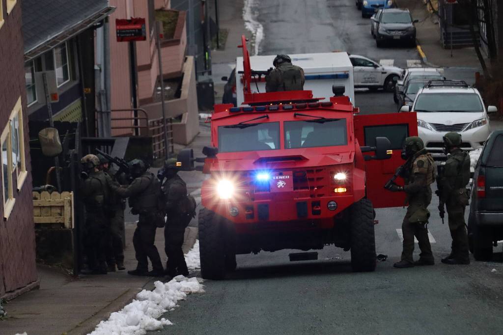 Juneau Police Department and FBI officers are deployed outside a downtown residence at midday Thursday, with JPD attempting to serve a search warrant for the house and a person inside. (Mark Sabbatini / Juneau Empire)