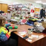 Martha Crockroft (foreground) and Jeff Marks wrap gifts for the annual Adopt-A-Family Christmas Gift Program at the St. Vincent de Paul Juneau complex on Saturday. (Mark Sabbatini / Juneau Empire)
