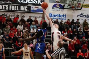 Sean Oliver (11) of Juneau-Douglas High School: Yadaa.at Kalé and Mande Wanlemvo of Auburn Mountainview High School fight for the tipoff at the start of their first Capital City Classic game Wednesday night at JDHS. (Mark Sabbatini / Juneau Empire)