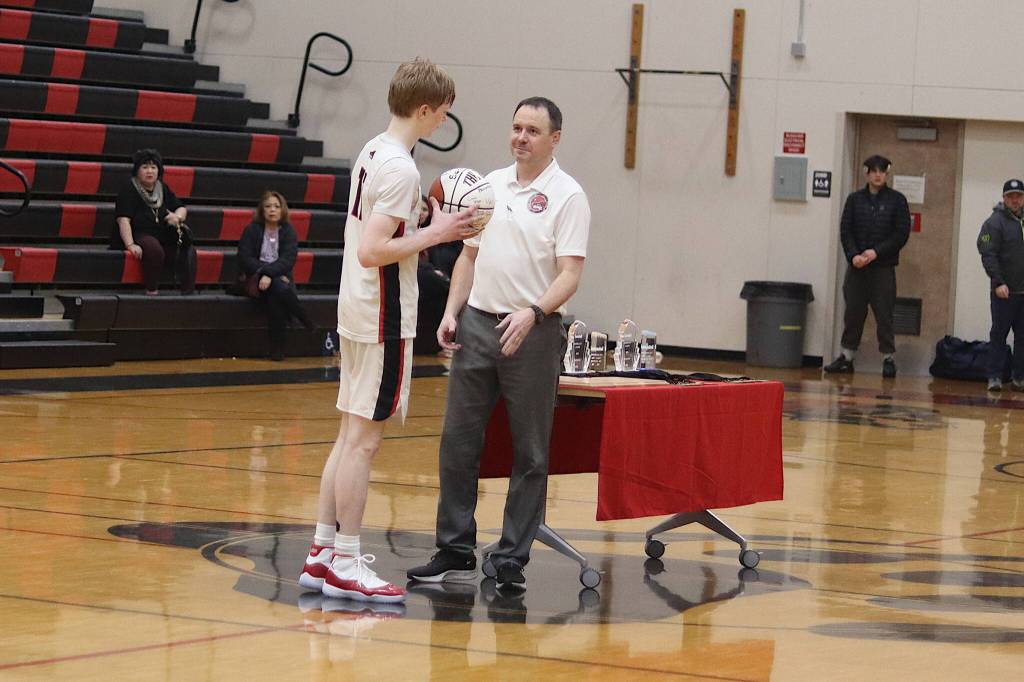Sean Oliver, a senior guard for Juneau-Douglas High School: Yadaa.at Kalé, is presented with a 1000+ career point award during the post-tournament ceremony at the Capital City Classic on Saturday night at JDHS.