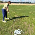 The authors wife lines up to hit a golf ball at a driving range in Tucson last week. (Photo by Jeff Lund)