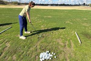 The authors wife lines up to hit a golf ball at a driving range in Tucson last week. (Photo by Jeff Lund)
