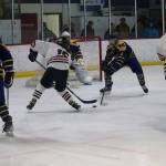 Juneau-Douglas High School: Yadaa.at Kalés Caden Morris (#15) and Sonny Monsef (#11) face off against Homer High Schools Aria Hill (#27) and Cody Thomas (#8) in front of the Homer net during Saturdays game at Treadwell Arena. (Mark Sabbatini / Juneau Empire)