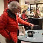 John Staub looks at a decades-old rotary-dial telephone that was in use at his home until a couple of years ago when he discontinued his landline service. He recently lent it to the Juneau-Douglas City Museum exhibit Switch and Exchange: A Brief History of Telephones in 20th Century Juneau, which Staub and dozens of other people attended the opening of Friday. (Mark Sabbatini / Juneau Empire)