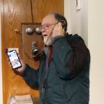 Skip Gray holds a simulated conversation on an early 20th-century box phone and his cell phone during the opening of the exhibit Switch and Exchange: A Brief History of Telephones in 20th Century Juneau at the Juneau-Douglas City Museum on Friday. Gray is a former resident of the Telephone Hill neighborhood, which got its name when Juneau became the first city in Alaska with an established telephone system and a telephone company called the downtown area home during the early 1900s. (Mark Sabbatini / Juneau Empire)