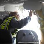 In this photo released by the National Transportation Safety Board, NTSB Investigator-in-Charge John Lovell examines the fuselage plug area of Alaska Airlines Flight 1282 on Sunday in Portland, Ore. A panel used to plug an area reserved for an exit door on the Boeing 737 Max 9 jetliner blew out Friday night shortly after the flight took off from Portland, forcing the plane to return to Portland International Airport. (National Transportation Safety Board via AP)