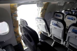 This photo released by the National Transportation Safety Board shows a gaping hole where the paneled-over door had been at the fuselage plug area of Alaska Airlines Flight 1282 on Sunday in Portland, Ore. A panel used to plug an area reserved for an exit door on the Boeing 737 Max 9 jetliner blew out Jan. 5, shortly after the flight took off from Portland, forcing the plane to return to Portland International Airport. (National Transportation Safety Board via AP)