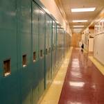 The halls are lined with lockers and portraits of elders at the Anna Tobeluk Memorial School in Nunapitchuk on Oct. 12, 2023. (Photo by Claire Stremple/Alaska Beacon)
