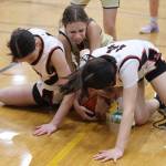 Nadia Wilson, left, and Layla Tokuoka, right, of Juneau-Douglas High School: Yadaa.at Kalé fight for possession of the ball with Skylar Morris of South Anchorage High School during Saturdays game at JDHS. (Mark Sabbatini / Juneau Empire)