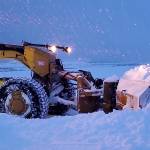 A state Department of Public Transportation and Public Facilities plow clears heavy snow from a road. The department has closed Thane Road overnight Monday and Tuesday due to the high risk of avalanches. (Alaska Department of Public Transportation and Public Facilities photo)