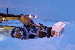 A state Department of Public Transportation and Public Facilities plow clears heavy snow from a road. The department has closed Thane Road overnight Monday and Tuesday due to the high risk of avalanches. (Alaska Department of Public Transportation and Public Facilities photo)