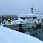 Local harbor workers clear snow from a boat in danger of sinking this week due to record snowfall. While boat owners are responsible for clearing their own vessels, city workers are forced to do so if a sinking poses environmental or other public safety hazards. (City and Borough of Juneau photo)