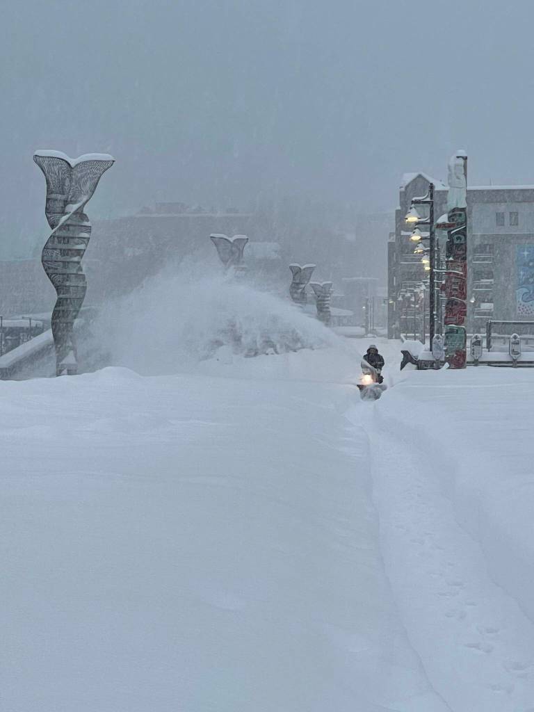 A city worker clears snow from the Seawalk in downtown Juneau this week. (City and Borough of Juneau photo)