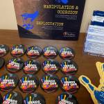 Educational materials about human trafficking filled a table outside of a Capitol room where human rights advocates spoke to lawmakers about how human trafficking affects Alaska on Jan. 24. (Photo by Claire Stremple/Alaska Beacon)