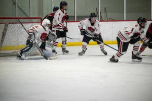 Members of Juneau-Douglas High School: Yadaa.at Kalés hockey team look to get the puck out of their end of the rink during Saturdays game against Houston High School at Treadwell Arena. (Photo courtesy of Bailey Hensen)