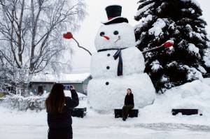 Isil Mico takes a photo of her sister-in-law Oznur Mico in front of Snowzilla, a snowman measuring more than 20 feet tall, in Anchorage, Alaska on Jan. 10, 2024. A recent storm dropped nearly 16 inches of snow on Anchorage, bringing the seasonal total to over 103 inches. Its the earliest Alaskas largest city has reached the 100-inch mark. (AP Photo/Mark Thiessen, File)