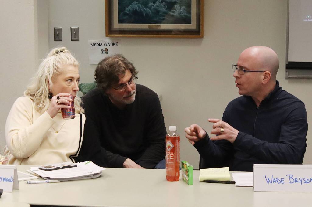 Assembly member Wade Bryson (right) discusses the Juneau School Districts financial situation with school board members David Noon and Britteny Cioni-Haywood during a break in a joint meeting of the Assembly and school board Tuesday night at City Hall. (Mark Sabbatini / Juneau Empire)