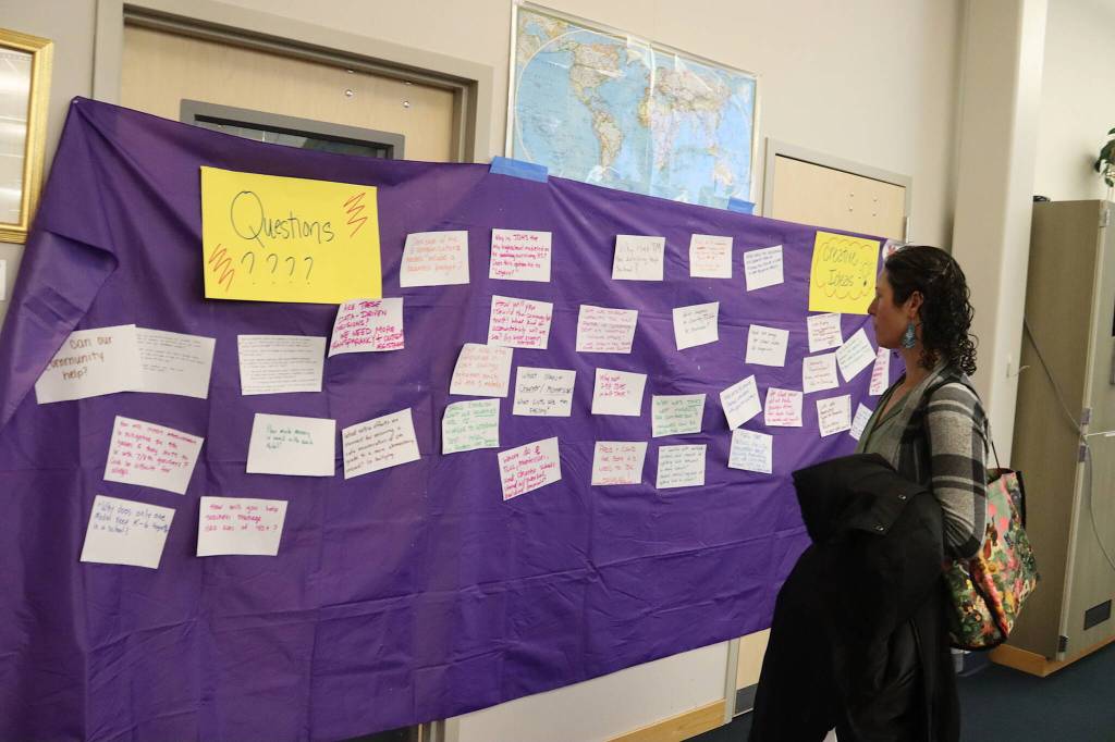 Tana OLeary, a parent of two elementary school students, reads comments from attendees at a Community Budget Input Session at Thunder Mountain High School on Wednesday night. (Mark Sabbatini / Juneau Empire)