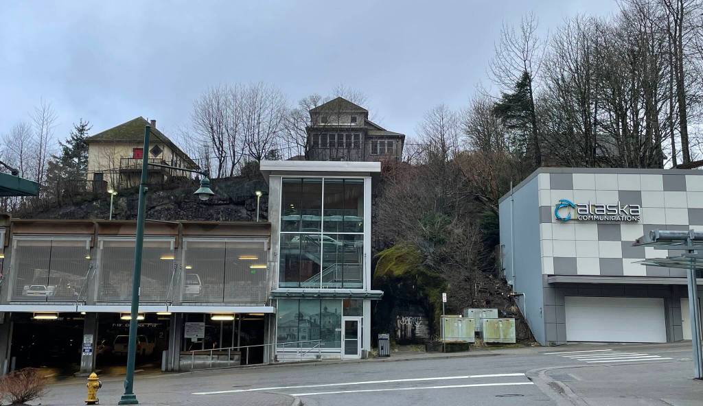 Looking up at the 1882 Edward Webster House on Telephone Hill from Second Street and Main Street in January 2024. Websters early telephone company operated from a 1915 addition to this house and gave the hillside its name. Note the decorative historic courthouse photo in the lower level window of the parking garage and the present ACS telephone building nearby. (Photo by Laurie Craig)
