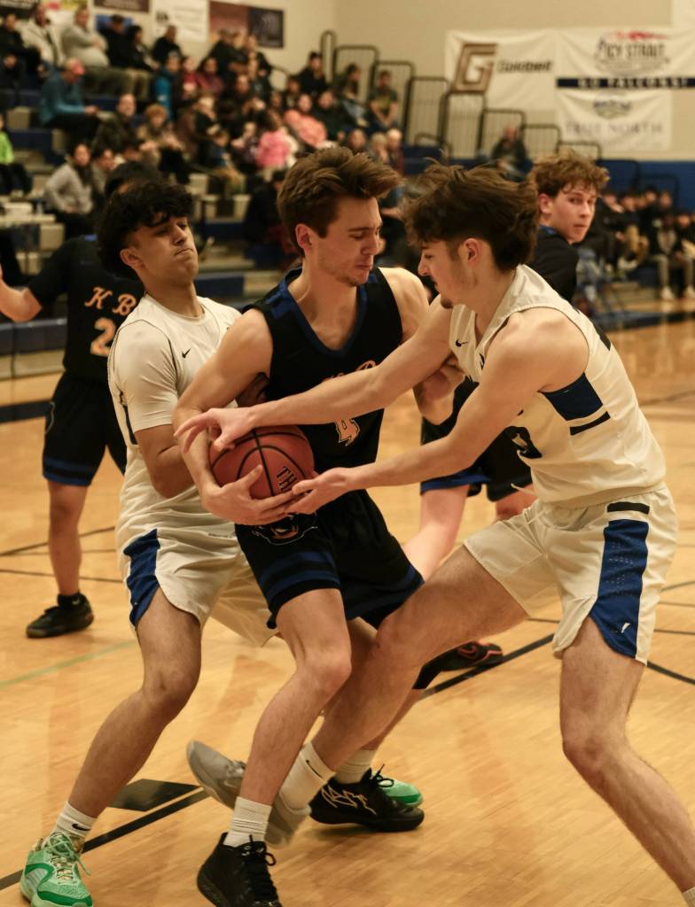 Thunder Mountain seniors Krishna Sanguni, left, and Harbor Thomas, right, battle for a ball with Kodiak senior MJ Bostwick (4) during the Falcons 71-49 win over the Bears, Thursday at the Thunderdome. (Klas Stolpe / For the Juneau Empire)