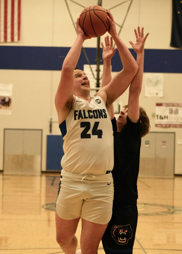 Thunder Mountain senior James Polasky (24) scores over Kodiak junior Liam Danelski during the Falcons 71-49 home win over the Bears, Thursday at the Thunderdome. (Klas Stolpe / For the Juneau Empire)
