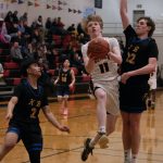 Juneau-Douglas High School: Yadaa.at Kalé senior Sean Oliver (11) scoops a shot against Kodiak junior Liam Danelski (22) during the Crimson Bears 75-50 win over the Bears on Saturday at the George Houston Gymnasium. (Klas Stolpe/For the Juneau Empire)
